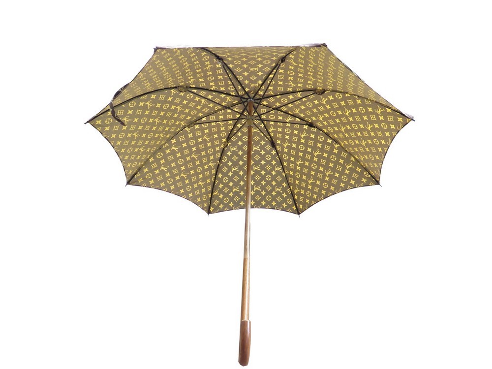 Louis VUITTON : Parapluie en toile Monogram, poignée en résine ambrée, L.  75 cm.